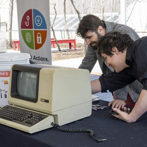 HUIT staff inspect an old computer for recycling at Earth Day