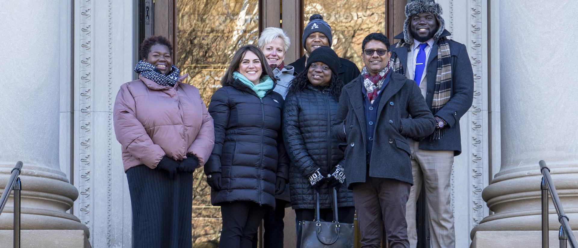 HUIT staff and Technology Enablement Initiative participants standing on library steps