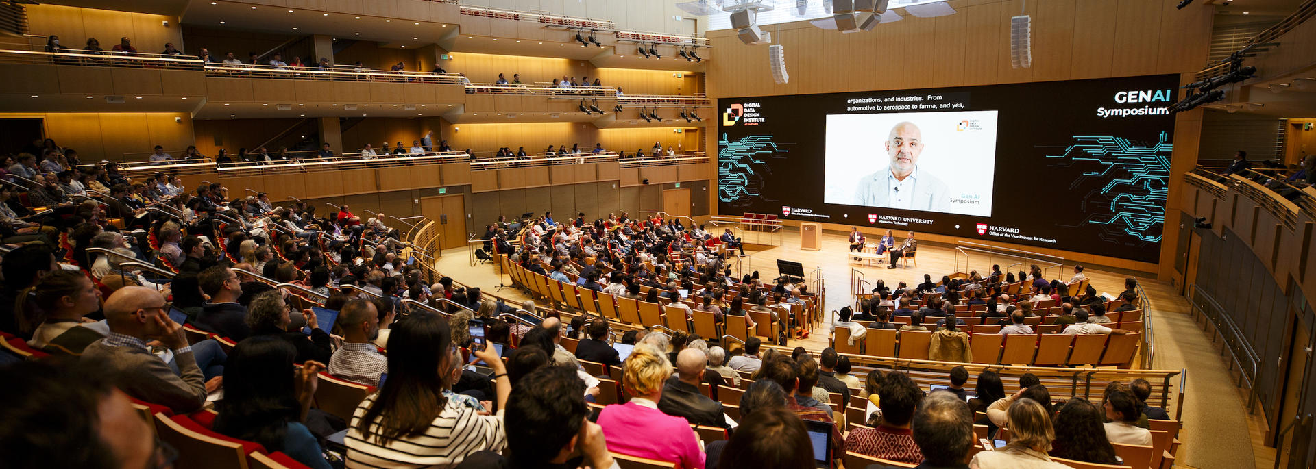 Attendees gather in a lecture hall for the AI Symposium